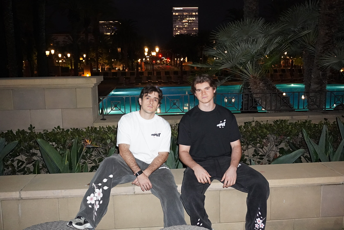 Two people wearing INPUT beside a pool at night